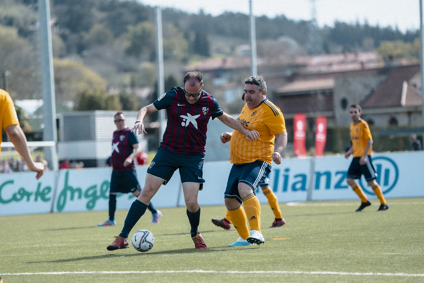 Un jugador de la SD Huesca Genuine protegeix la pilota enfront d'un altre de la SD Ponferradina Genuine en un dels partits disputats a la Ciutat Esportiva de Lezama en LaLiga Genuine Santander.